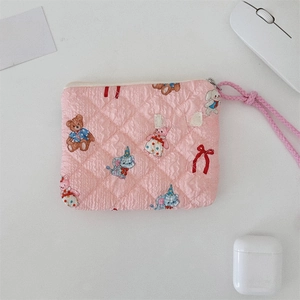 Detail of pink quilted pouch with cartoon bear elephant prints and side brand label