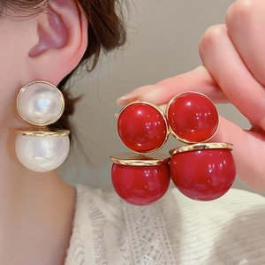 Gros plan de boucles d'oreilles perles double face élégantes en résine rouge et blanche