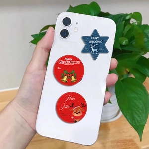 Close-up of festive Christmas gift tag stickers applied to a white mobile phone case