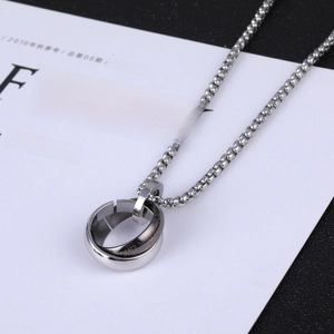 Detail view of interlocking silver rings with engraved letters on a bead chain necklace