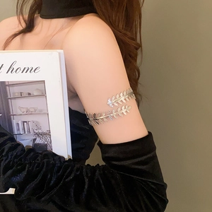 Macro detail of the silver leaf arm cuff featuring intricate leaf texture and overlapping design