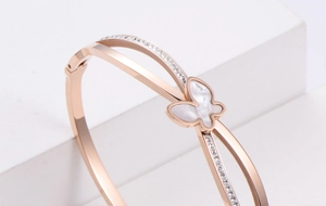 Macro shot of rose gold butterfly bracelet with white mother of pearl and crystal inlay