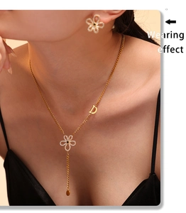 Model wearing gold flower necklace and D pendant with matching stud earrings