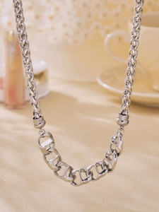 Close-up of interlocking silver geometric links on a polished stainless steel chain