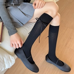 Black knee-high vertical striped socks with ribbon bows and Mary Jane shoes