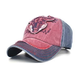 Detail of vintage washed cotton baseball cap with bull embroidery and distressed texture
