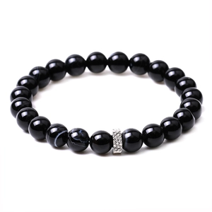 Macro shot of polished black agate beads with silver metal spacers on a couple bracelet