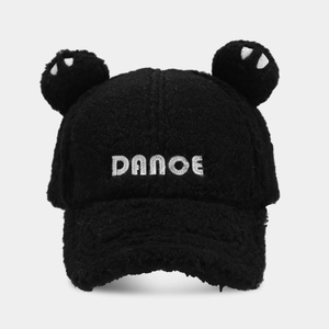 Close-up of black plush baseball cap featuring cute ears and white DANCE embroidery detail