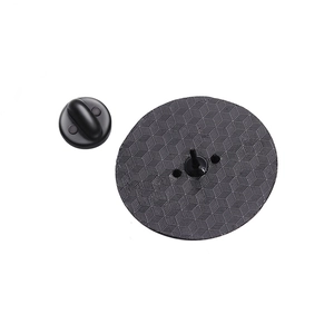 Detail view of the black metal badge back with rubber clutch and textured surface