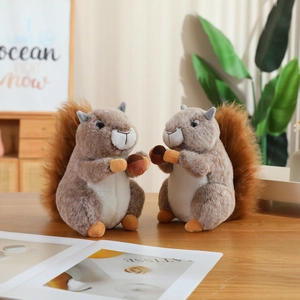 Cute plush squirrel dolls with fluffy tails and nuts on a wooden table home decor