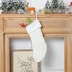 Détail d'une chaussette de Noël en tricot blanc avec bordure pelucheuse sur une cheminée