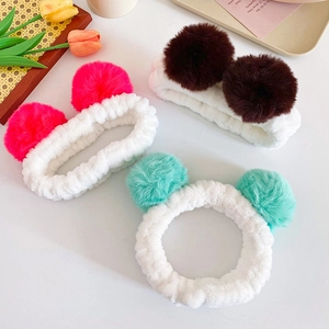 Three plush spa headbands with colorful pom poms for face washing and skincare