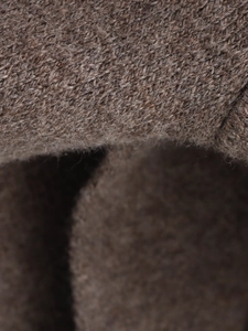 Macro shot of brown wool fabric texture and knit weave on a warm winter coat scarf
