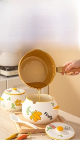 Detail of pouring hot oil into heat-resistant ceramic seasoning jar with lid and wooden tray