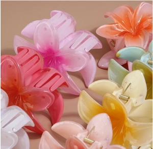 Macro detail of colorful resin flower hair claws with durable golden metal springs