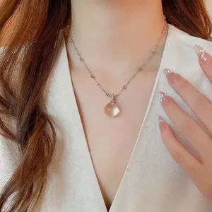 Elegant silver bead necklace with a sparkling crystal ball pendant on a female model