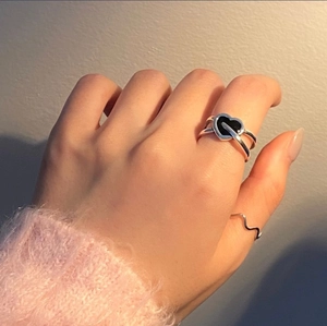 Elegant 925 sterling silver ring set with black heart and wavy bands on model