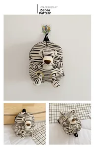 Detail view of plush zebra pattern toddler backpack with a cute stuffed animal attachment