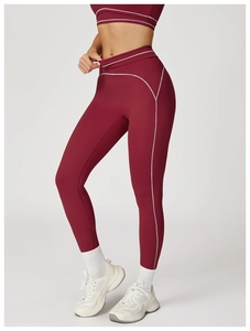 Detail view of burgundy high-waist yoga pants with white contrast stitching and matte fabric