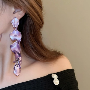 Detail of purple petal-shaped drop earrings with elegant long tassels worn by a model