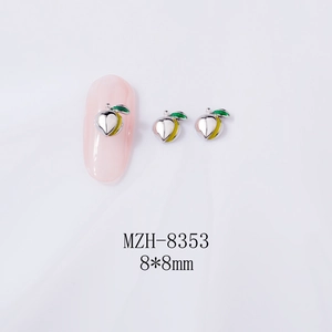 Detail of 3D alloy peach nail charms with green enamel leaves on pink manicure