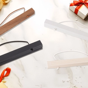 Close-up of magnetic wood poster hangers in four colors on marble surface for wall art