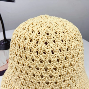 Close-up of beige knit bucket hat showing detailed geometric hollow crochet pattern