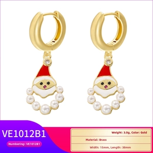 Detailed macro view of gold-tone Santa Claus drop earrings with red enamel and white pearls