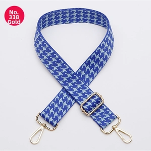 Macro shot of blue houndstooth wide bag strap with shiny gold swivel hooks and buckle