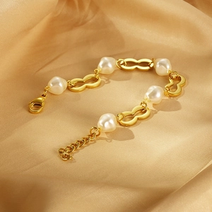 Détail du bracelet plaqué or 18K avec maillon en résine et perle baroque sur soie