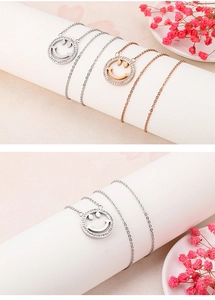 Close-up of minimalist smiling face pendant necklace with rhinestone edges in silver and rose gold
