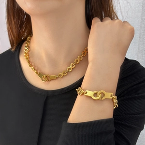 Gold titanium steel jewelry set with handcuff link necklace and matching bracelet on model