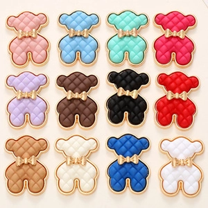 Detailed grid of assorted colorful bear charms with gold bows and quilted texture