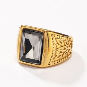 Detail of gold ring with large rectangular grey stone and engraved leaf patterns