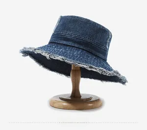 Detail shot of a dark blue washed denim bucket hat with distressed frayed edges
