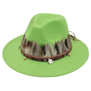 Detail eines hellgrünen Filzhutes mit Boho-Federschmuck und Metallmünzenanhänger