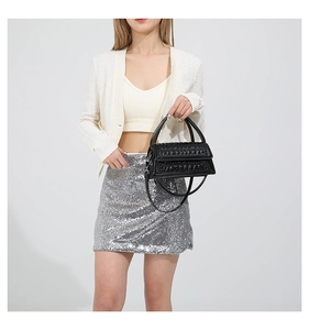 Detailed view of the black crocodile pattern texture and handle on a stylish handbag