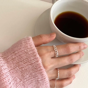 Close-up of a 925 sterling silver chain ring worn on finger with a textured pink sweater