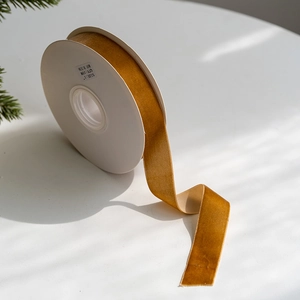 Gros plan d'un ruban en velours doré de 2,5 cm pour emballages cadeaux de Noël DIY