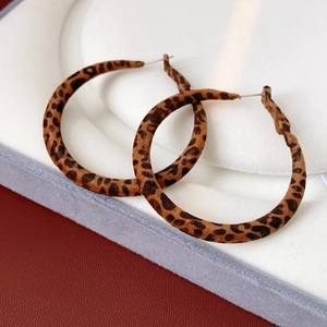 Gros plan de boucles d'oreilles rondes imprimé léopard avec texture floquée marron