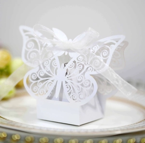 Macro detail of white hollow butterfly wedding candy box with laser-cut patterns