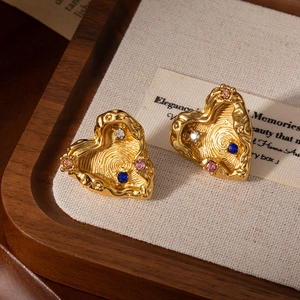 Golden heart stud earrings with lava texture and colorful zircon stones on linen