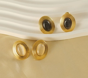 Vue détaillée de boucles d'oreilles ovales en acier doré avec pierres œil de chat