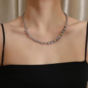 Close-up of titanium steel necklace with blue and yellow stone beads on model neck