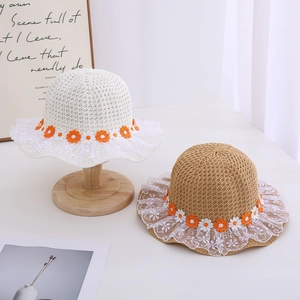 Close-up of children's straw sun hats with daisy ribbons and delicate white lace edges