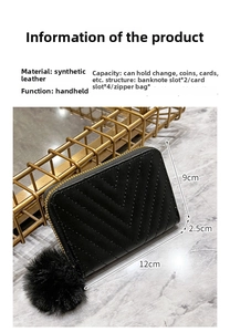 Close-up of black V-quilted faux leather wallet with fur pompom and metal zipper details