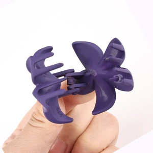 Detailed close-up of dark purple matte flower hair claw clip with strong metal spring