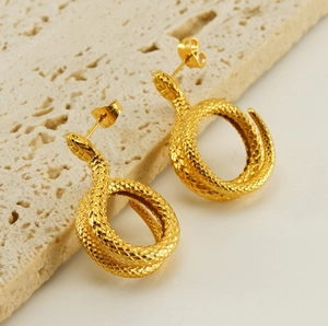 Macro shot of 18K gold plated snake stud earrings with textured scale details