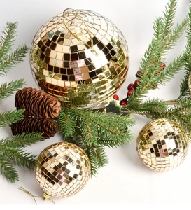 Detail of golden mirror disco balls with festive pine branches and red berries decorations