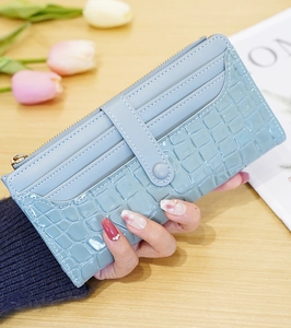 Detail of light blue faux crocodile texture wallet with card slots and golden zipper